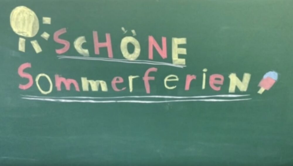 Auf der Tafel mit bunter Kreide geschrieben: Schöne Sommerferien