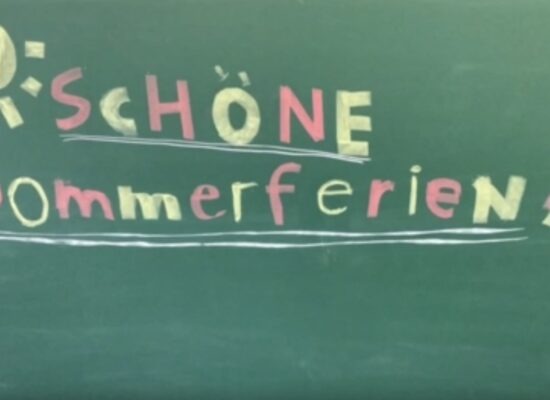 Auf der Tafel mit bunter Kreide geschrieben: Schöne Sommerferien