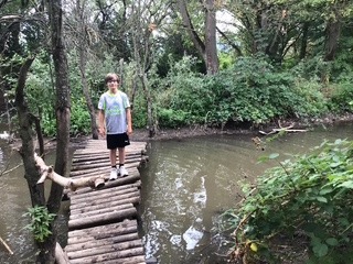 Schüler auf einer Holzbrücke über den bach