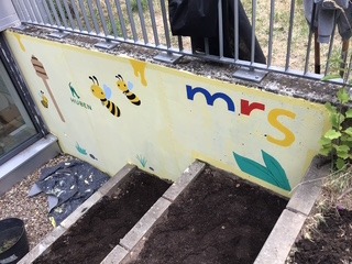 Foto einer mit Bienen bemalten Betonmauer