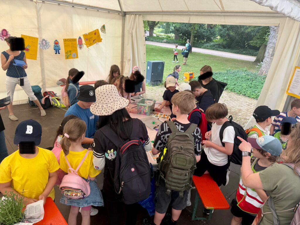 Besucher beim Ausprobieren der Station der Merian Realschule