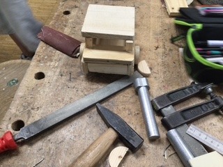 technik Bild eines selbstgebauten Holzautos mit Hammer, Feile und Schraubstock